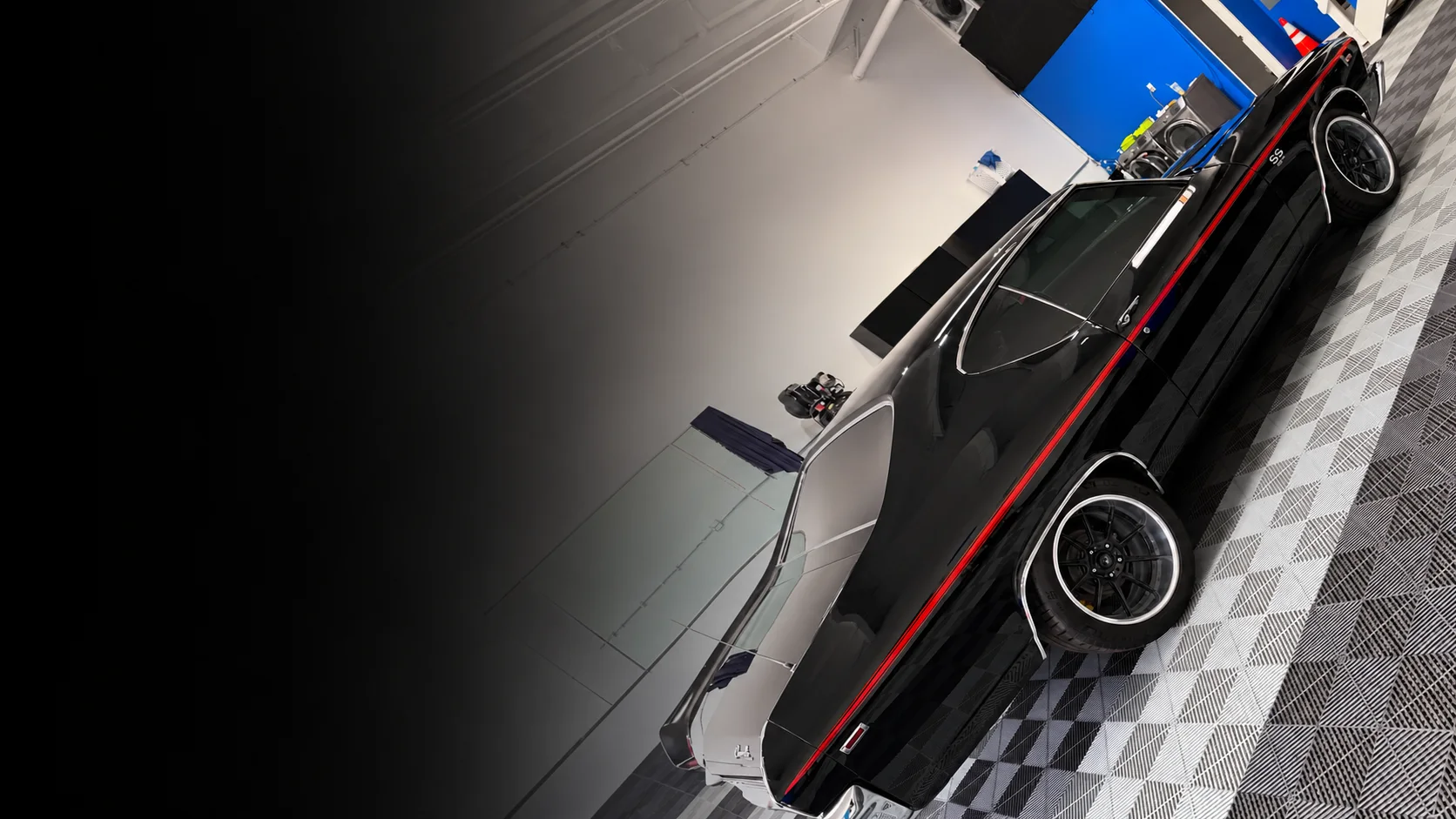 Black performance vehicle photographed inside a styling shop