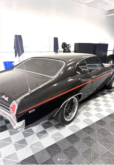 Black sedan with dark rear window tint inside the shop
