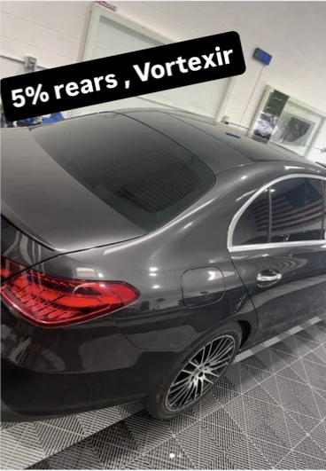 White sedan photographed in the shop after windshield tint work